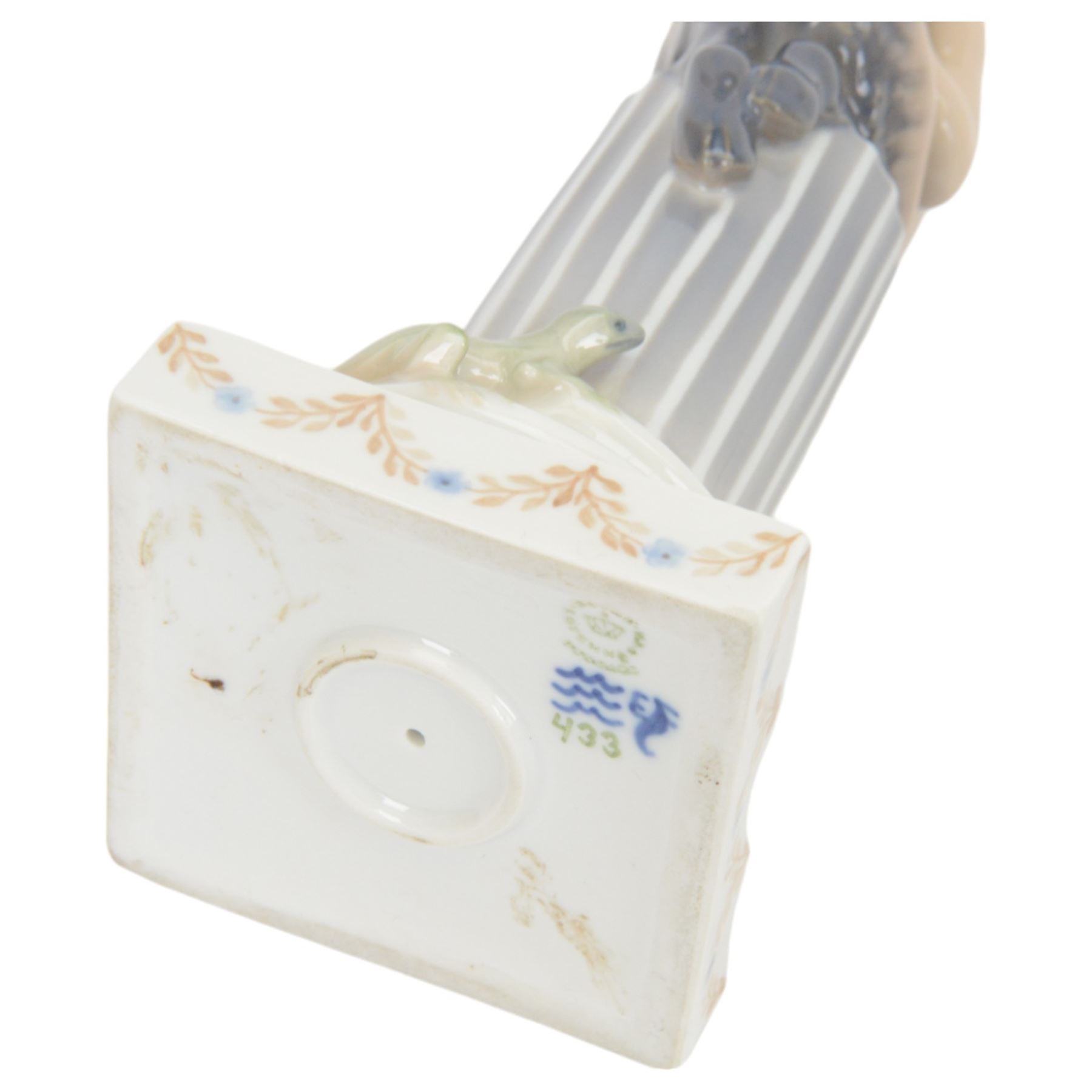 Two Royal Copenhagen figurines of fawns, comprising a fawn with an owl, no 2107 and fawn on plinth no 433, together with Bing & Grondahl, figure of a parrot on branch