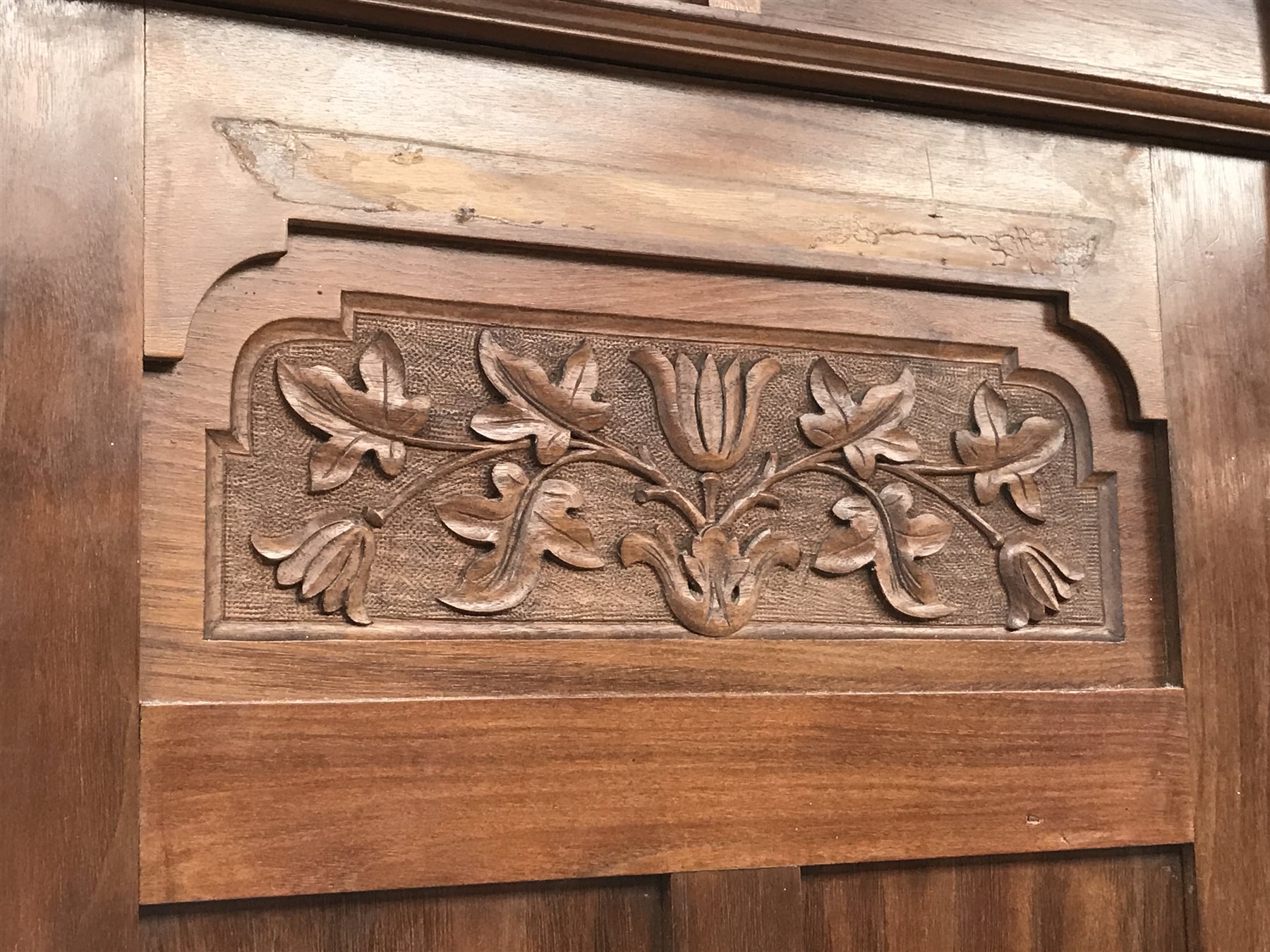 Irish Arts & Crafts walnut triple wardrobe circa 1908, projecting cornice above three doors enclosing fitted interior, single full length bevel edge mirror, platform base, W173cm, H204cm, D56cm