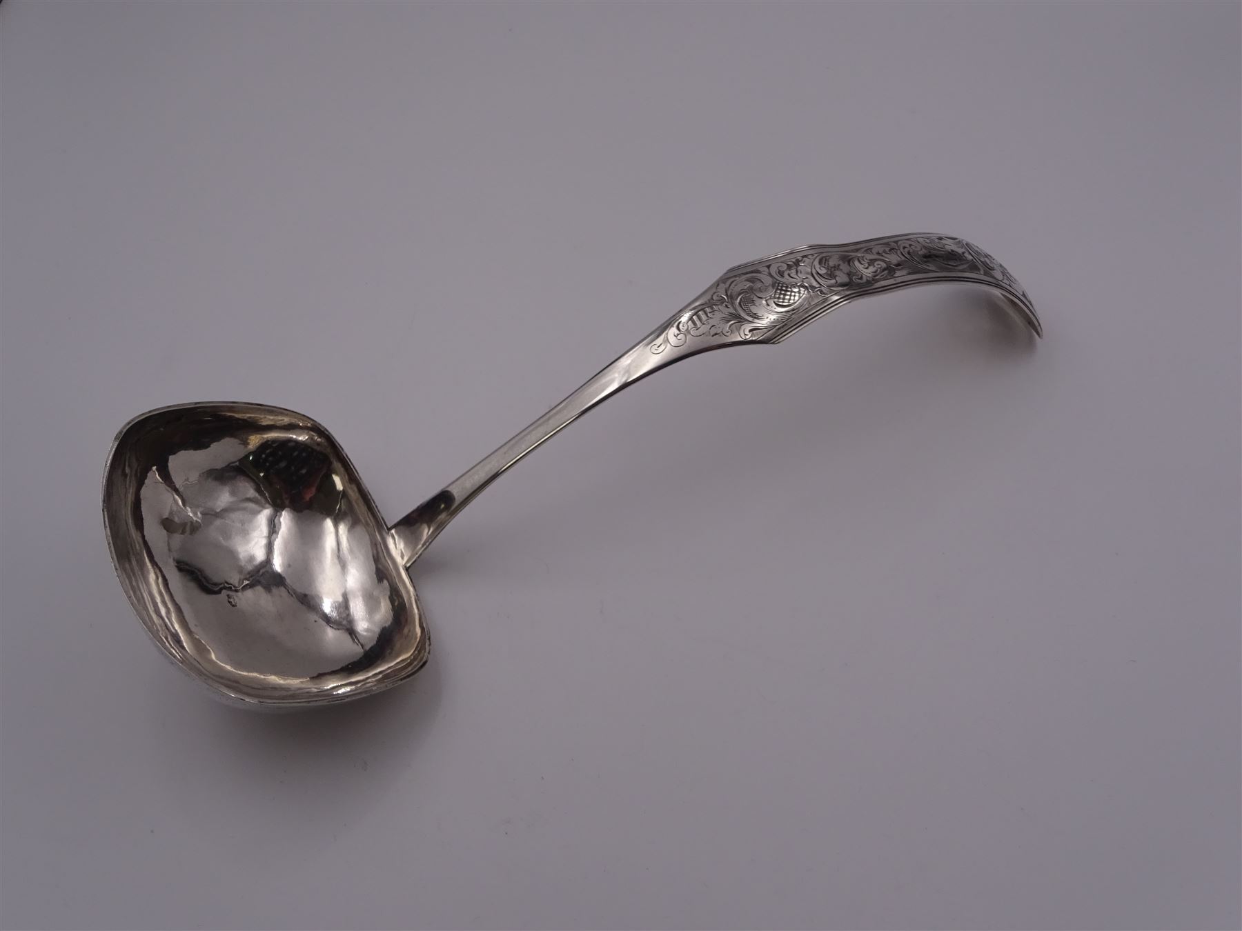 Mid 19th century Dutch silver 833 standard soup ladle, with rounded rectangular bowl, the shaped and curved stem engraved with foliate scrolls, marked with Lion Passant, Minerva Head with letter A for Amsterdam, date letter for 1847 and makers mark, approximate L30cm, approximate weight 4.52 ozt (140.6 grams)