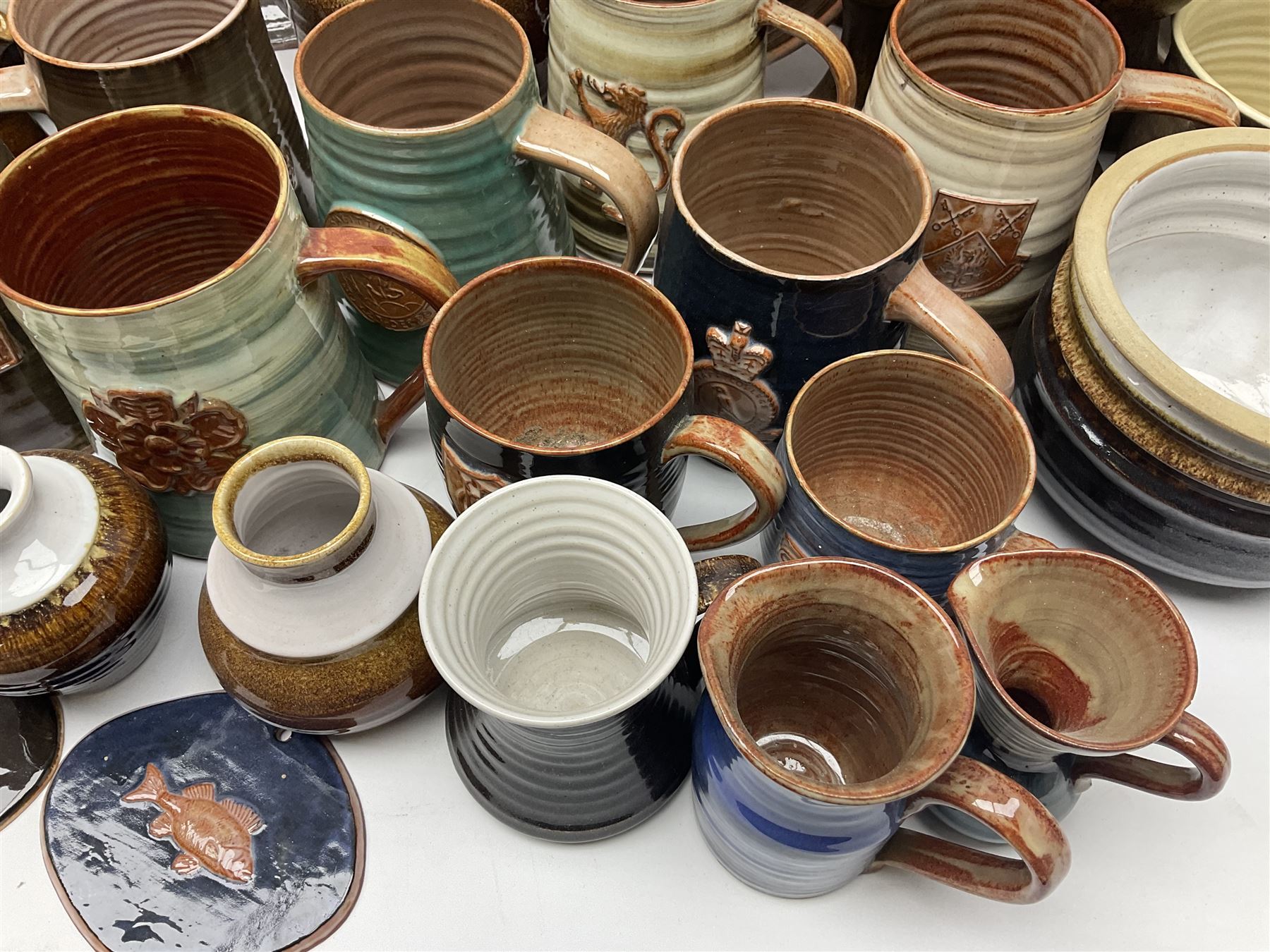Wold studio pottery tankards, in various colours and relief decoration together with other studio items including vases, jugs and pots 
