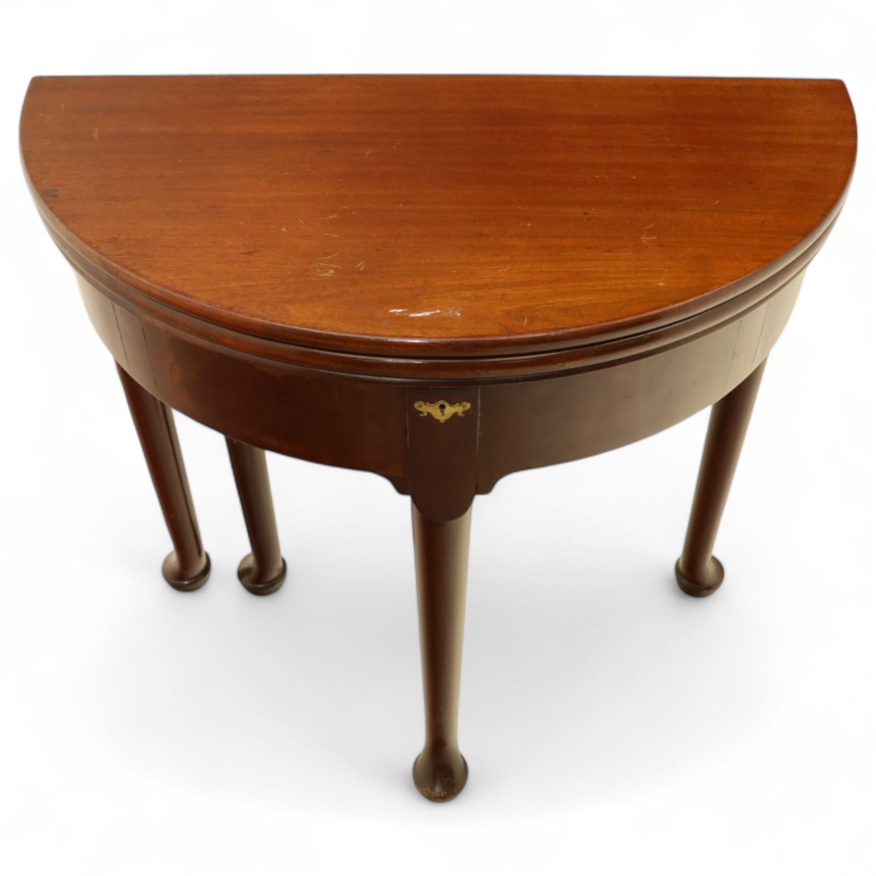 20th-century Georgian Revival style double fold-over card table, the first hinged circular top with polished mahogany surface above a second hinged circular top revealing a green baize playing surface with four counter-wells, underneath with a recessed compartment with and  chip and dice wells, the apron with fitted lock and key, raised on slender straight legs with pad feet 