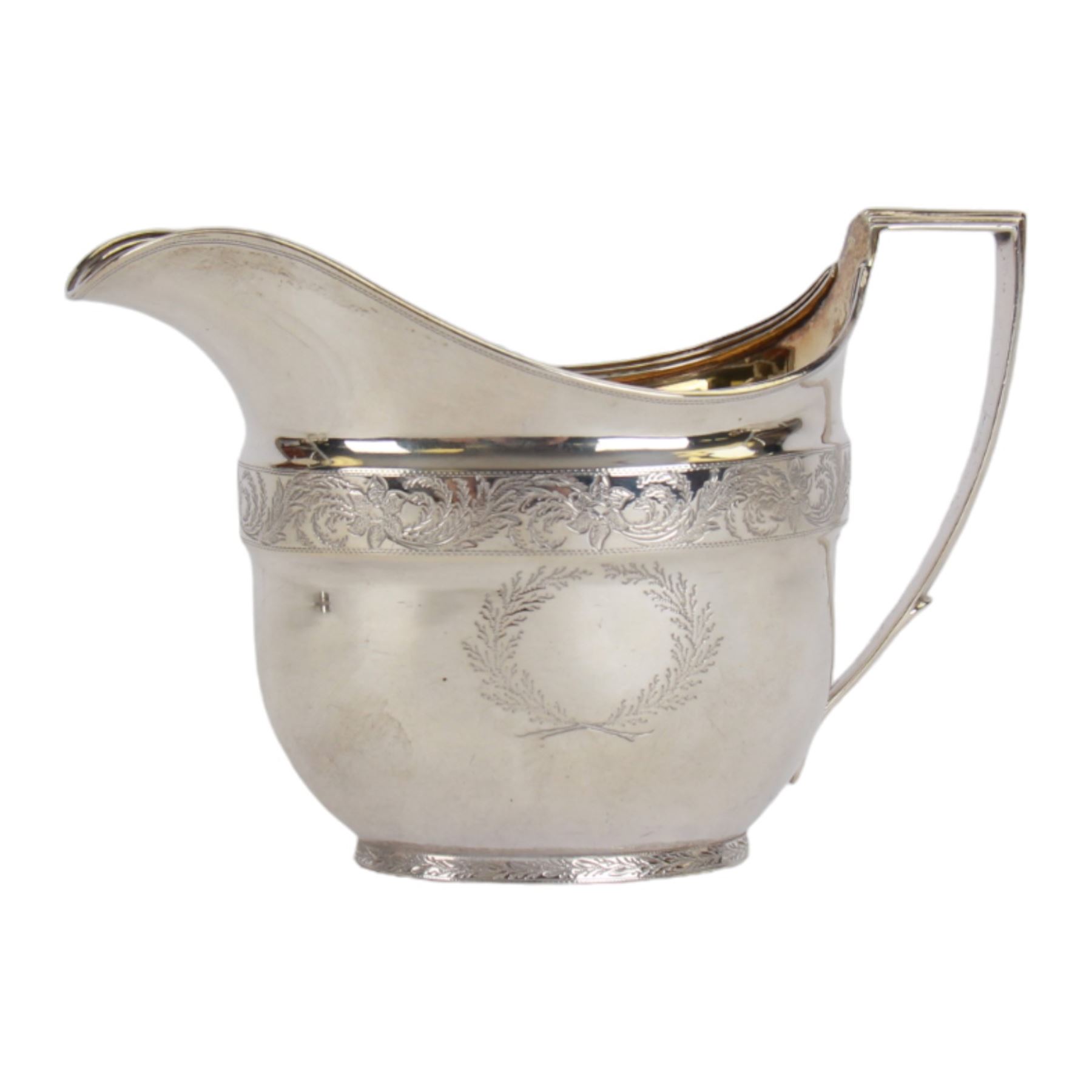 George III silver three piece tea service, comprising teapot with ivory scroll capped curved handle and ivory finial to the hinged cover, twin handled open sucrier with gilt interior, and cream jug with gilt interior, each of oval form with rounded sides, the bodies engraved with central monogram within a seaweed wreath, between engraved foliate bands, hallmarked John Emes, London 1801, teapot including handle H17cm

This item has been registered for sale under Section 10 of the APHA Ivory Act