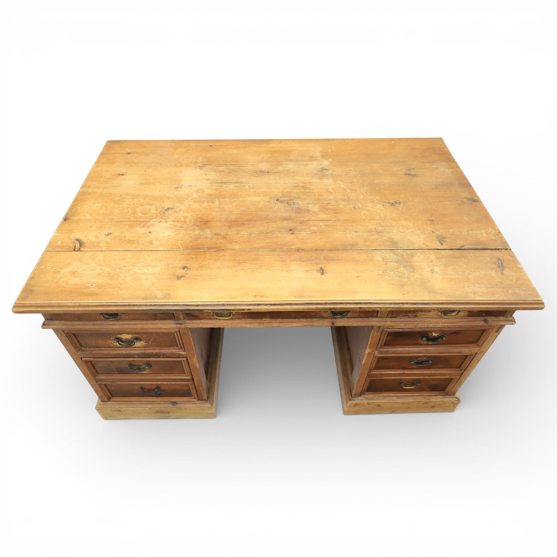 Late 19th century Victorian pine twin pedestal desk, rectangular plank top above an arrangement of seven drawers with brass swan neck handles, each pedestal fitted with one drawer above a double height drawer, raised on plinth bases with panelled sides