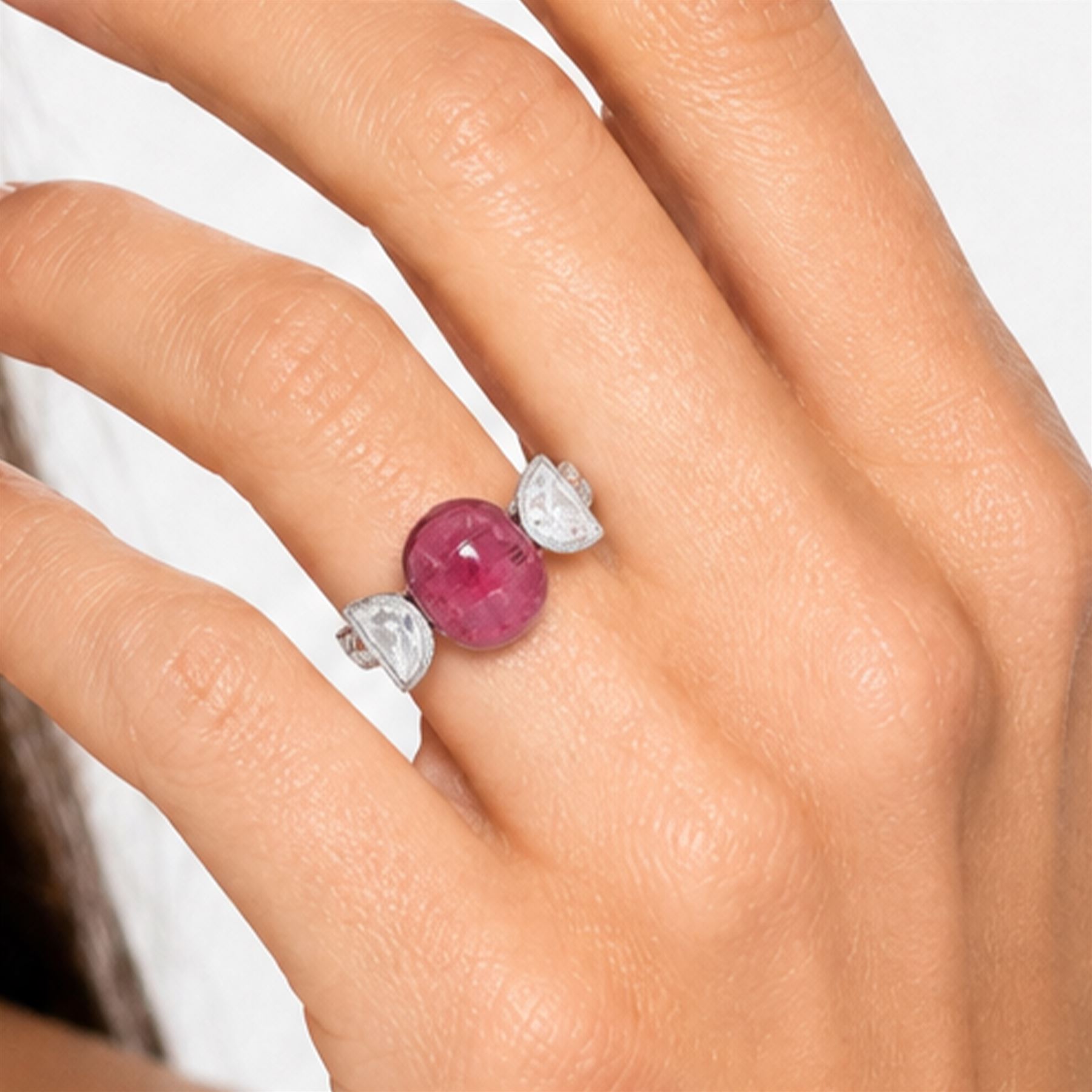 18ct white gold pink tourmaline and diamond ring, single oval cabochon cut tourmaline of approx 4.75 carat, set with a half moon cut diamond either side, to engraved laurel leaf design shoulders