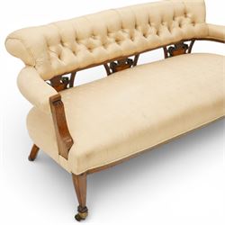 Edwardian inlaid mahogany sofa, upholstered in cream fabric with buttoned back rail, tapering legs on brass castors