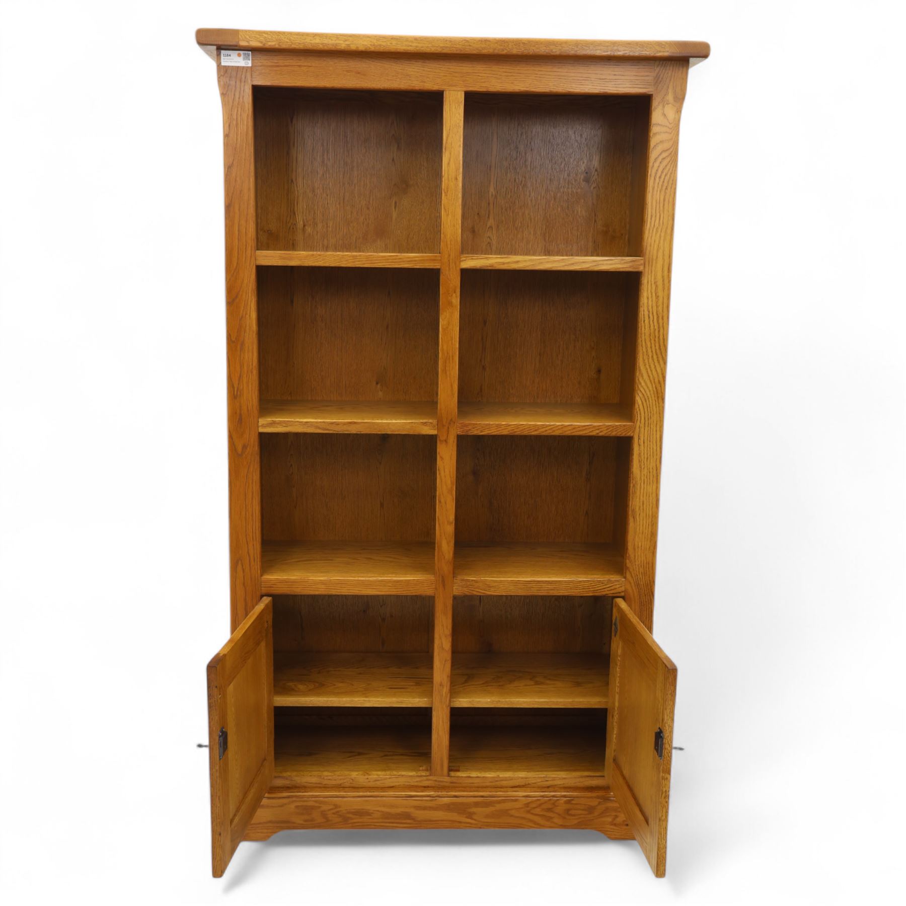 Old Charm - 'Chatsworth' light oak bookcase with two cupboards, featuring two fixed horizontal shelves forming six  rectangular open compartments, over twin panelled cupboard doors, chamfered uprights and plinth base