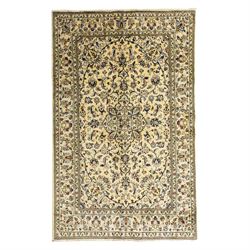 Central Persian Kashan hand-knotted rug, ivory ground, with a small central floral medalli...