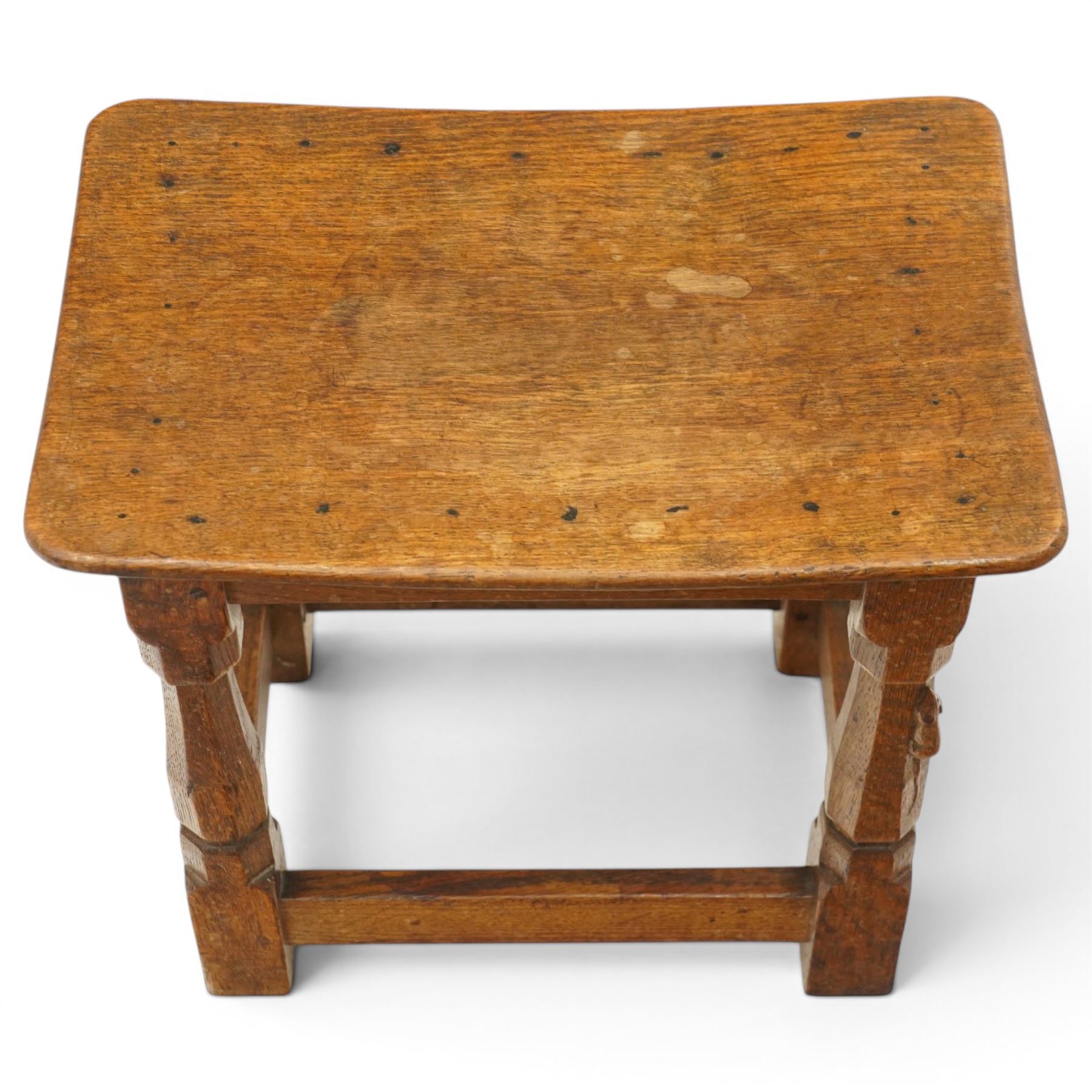 Mouseman - mid-20th century adzed oak joint stool, dished oak seat, on shaped octagonal supports joined by box stretcher, with carved mouse signature, by the workshop of Robert Thompson of Kilburn
