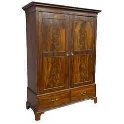 George III mahogany double wardrobe, the projecting cornice with dentil moulding over two panelled doors with mirror-lined interiors, enclosing hanging rails and brass hooks, the base fitted with two drawers, raised on bracket feet
