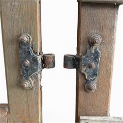 Pair of 19th century weathered wooden ecclesiastical church gates, the cresting rail over four pierced arches with slatted lower section, fitted with heavy cast iron hinges, latch and fittings