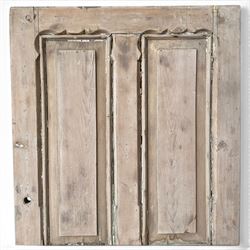 Victorian stripped pine four-panel door, the raised fielded panels within carved foliate and moulded surrounds, with iron lock and fittings and brass knob handle