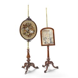 Two Victorian mahogany pole screens, comprising an oval example with floral needlework pan...