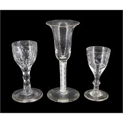 Three 19th century drinking glasses, the first example in the 18th century taste with bell shaped bowl upon a double series opaque twist stem and circular foot, H15.5cm, the second example with rounded funnel and floral engraved bowl upon a knopped stem and circular foot, H10cm, and the third example with rounded bowl with engraved and faceted border upon a diamond faceted stem and circular foot, H11.5cm