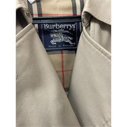 A ladies Burberry trench coat, with waist belt and check lining, no size label, measures approximately arm pit to arm pit L51cm, H117cm