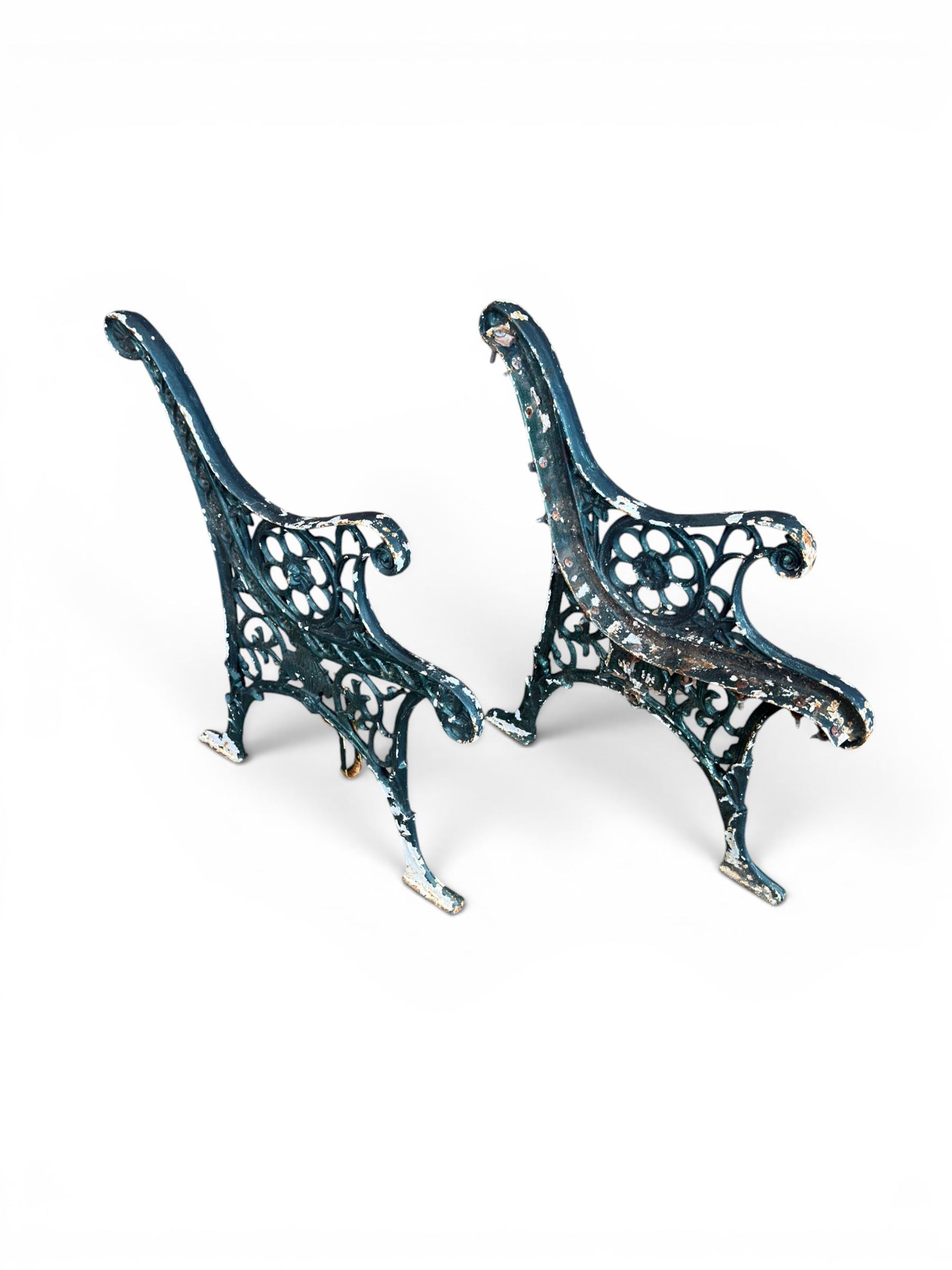 Pair of ornate painted cast iron bench ends, painted in green