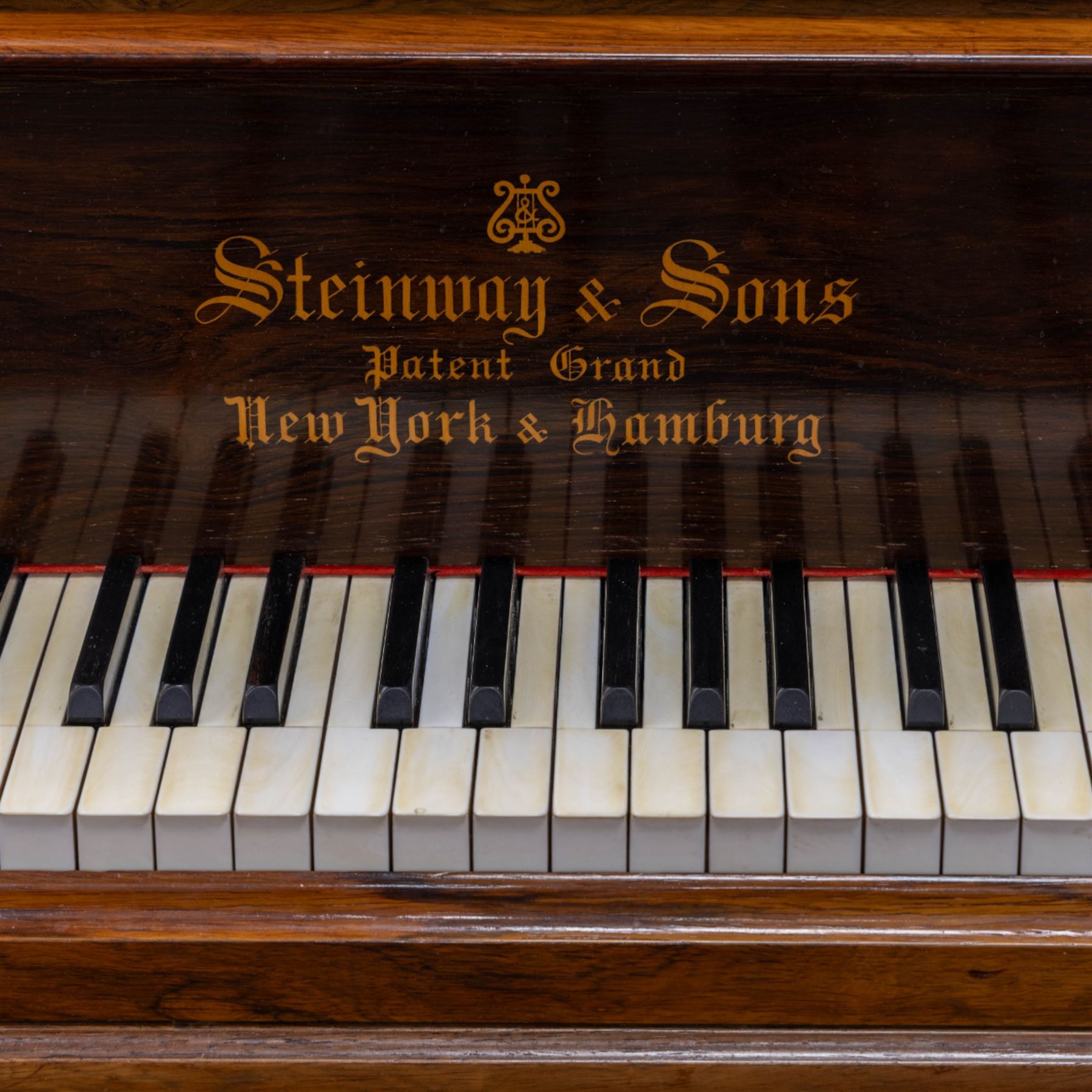 Steinway & Son, New York & Hamburg- Model B, overstrung Drawing Room Grand Piano in a rosewood case, Serial No 87297 (1896/7), with 85 ivory covered and ebony keys A0-A7(7 octaves) with an adjustable fretted music desk, brass fittings and pedals, Steinway “Fireplug” straight columnar and fluted legs with roller castors and conforming lyre, duplex stringing with agraffs, bass strings copper wound with a steel core, steel tuning pins, original Steinway action, hammers, keys, felts, and dampers, with una-corda, sostenuto and sustain pedals, Overstrung iron frame detailing numerous Steinway patents, awards, and features. Tuned to Concert pitch (A=440). 
With an adjustable single stool. 

This item has been registered for sale under Section 10 of the APHA Ivory Act HLB1KY67