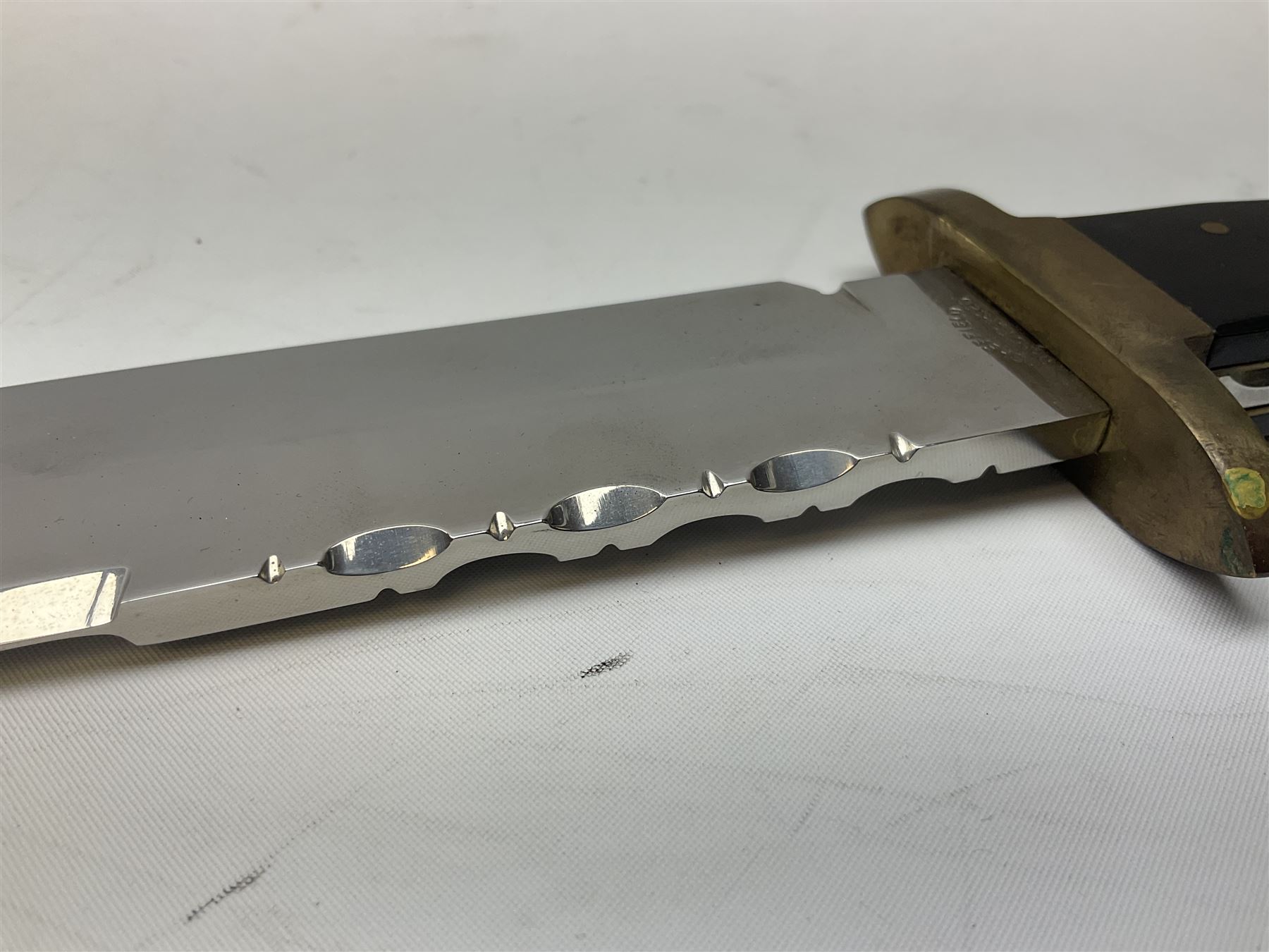 Large Bowie knife the 21cm steel blade marked J.E. Middleton & Sons Rockingham Street Sheffield with brass cross-piece and polished horn grip scales; in leather sheath L36cm overall