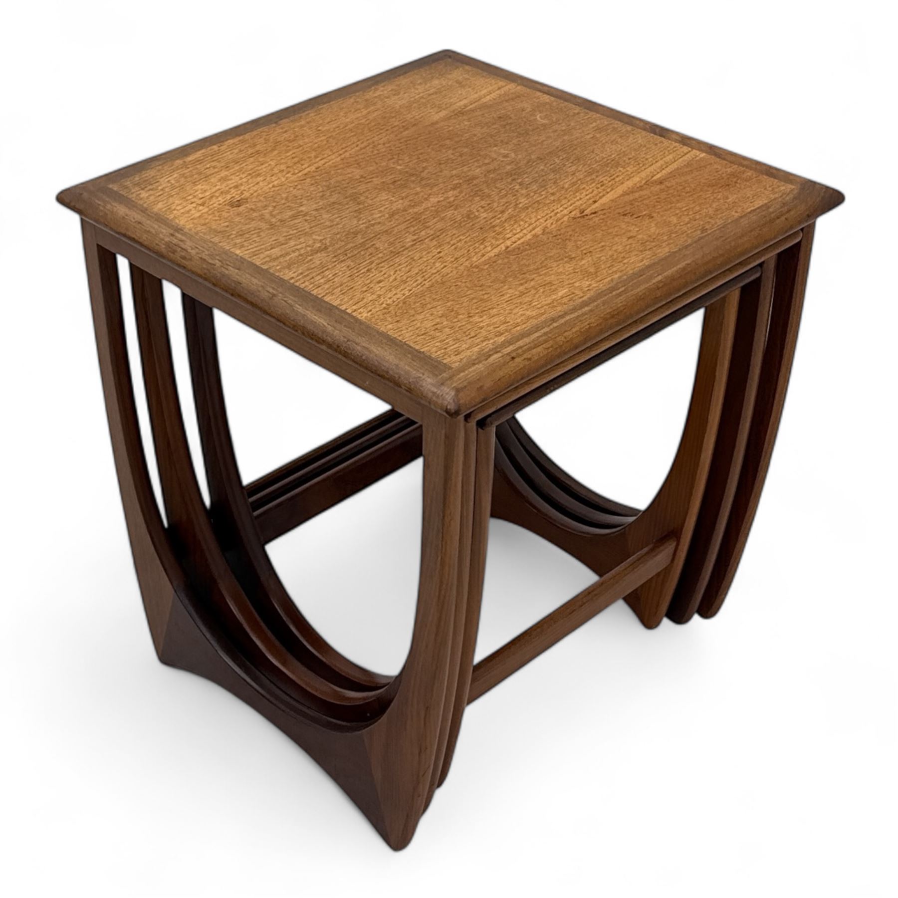 G-Plan - 'Astro' mid-century nest of three teak occasional tables, each with a square top with outer banding, on U-shaped end supports united by a stretcher
