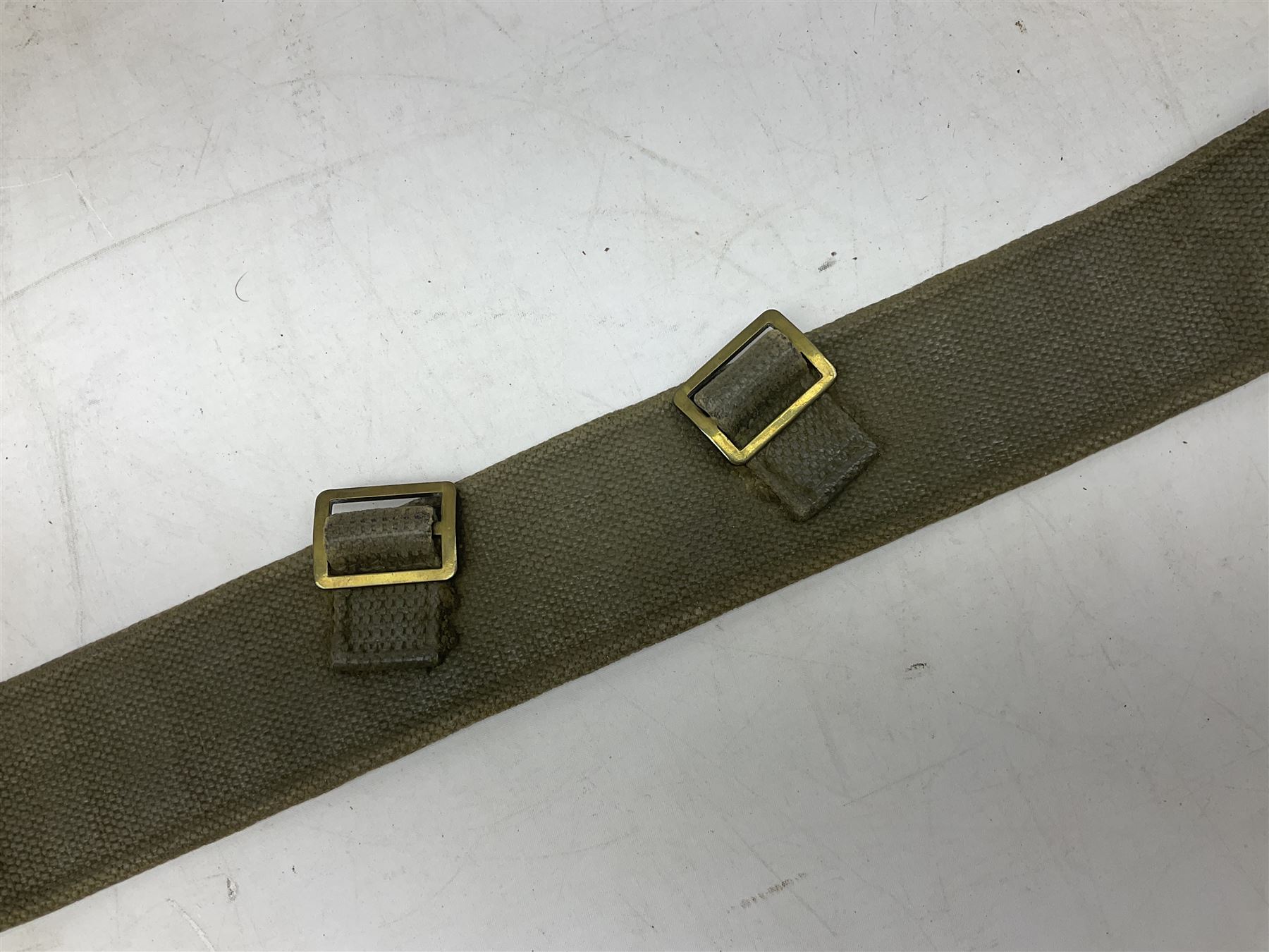 British Army Officers Sam Browne leather belt with shoulder strap; and webbing belt with Potter London Staybrite buckle for 19th Regiment of Foot (Green Howards) with various markings (2)