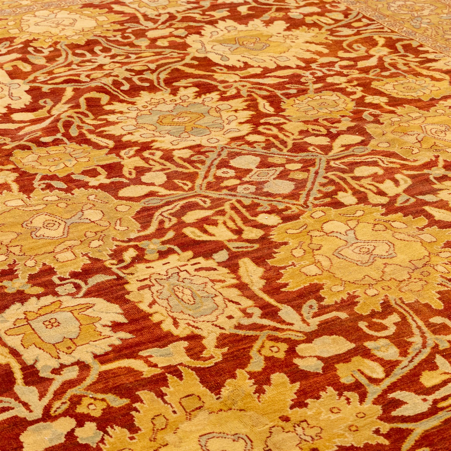 Central Persian Ziegler design hand-woven carpet, rich madder red field with central stylized lozenge medallion enclosed with an all-over lattice of scrolling vine, palmettes, and angular floral motifs of the Sultanbad tradition, broad ivory main border decorated with large-scale rosettes and flowering cartouches, flanked by narrow guard stripes, with fringe ends 