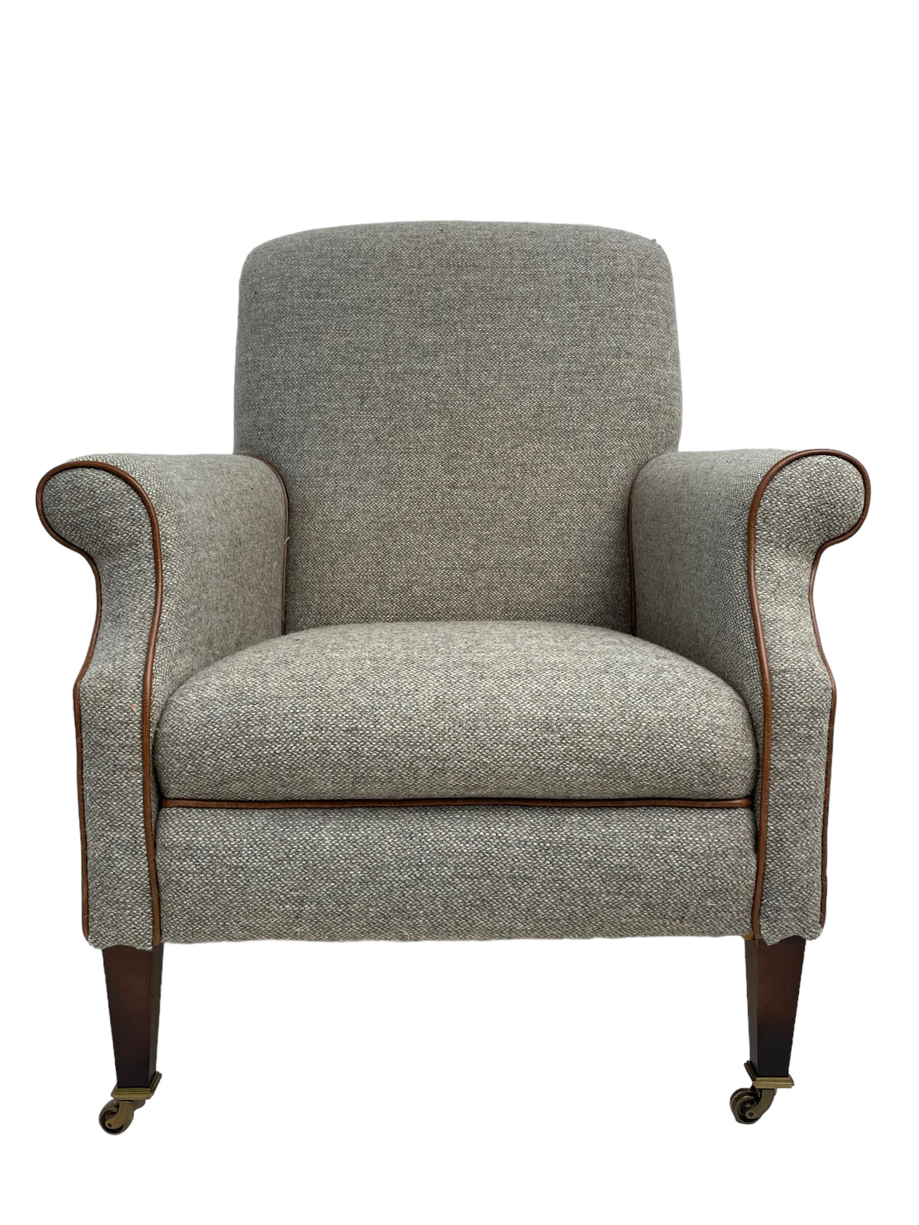 Interiors at Nine to Eleven - Edwardian design armchair, traditional shape with rolled arms, upholstered in 'Harris Tweed' fabric with leather piping, raised on square taping supports with castors