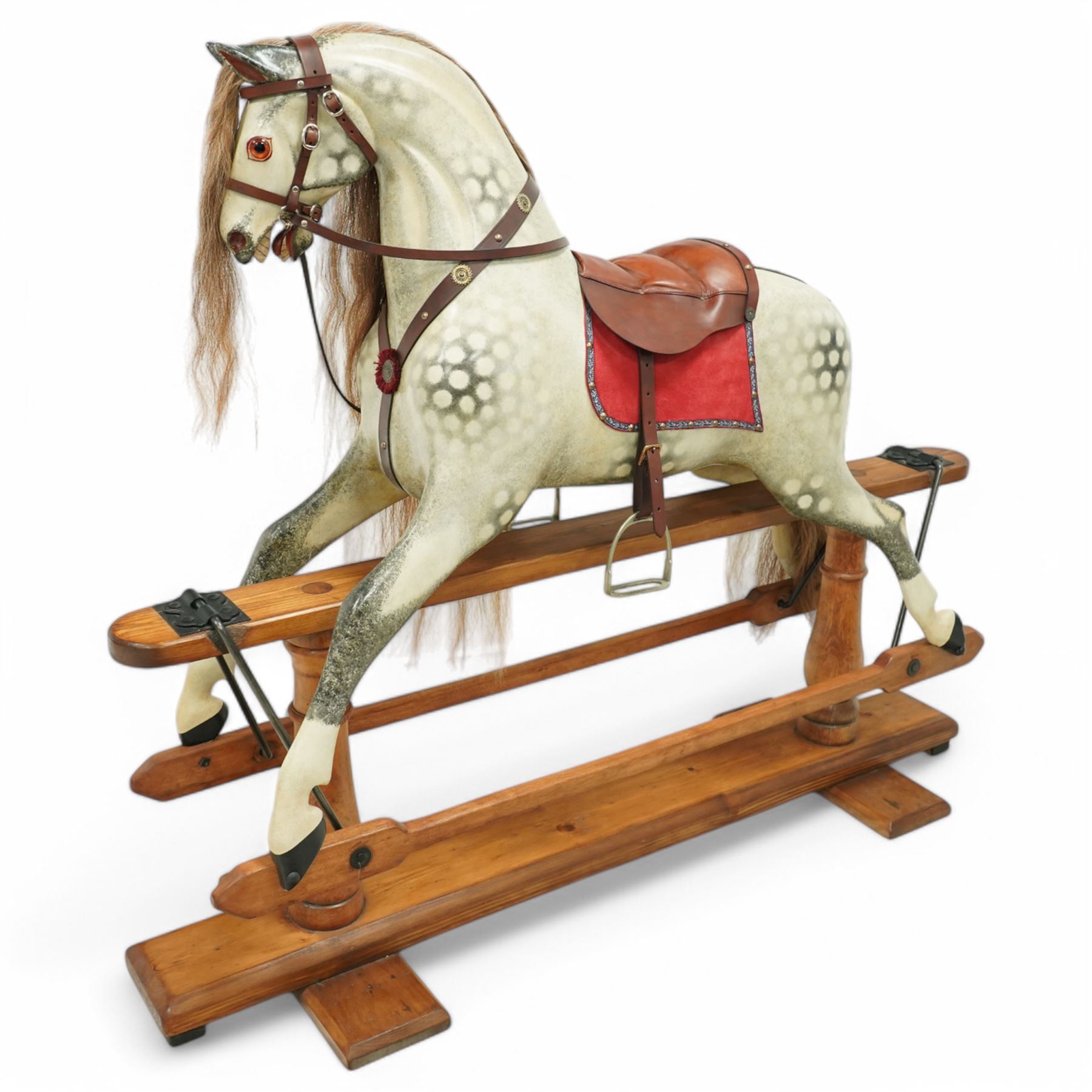 Frederick Henry Ayres (F H Ayres, London) - Late Victorian large carved wooden rocking horse, in dapple grey paint finish, decorated with glass eyes, leather reins, stirrup and saddle, indented hooves, on rockers united by chamfered stretchers and boarded base, c.1890