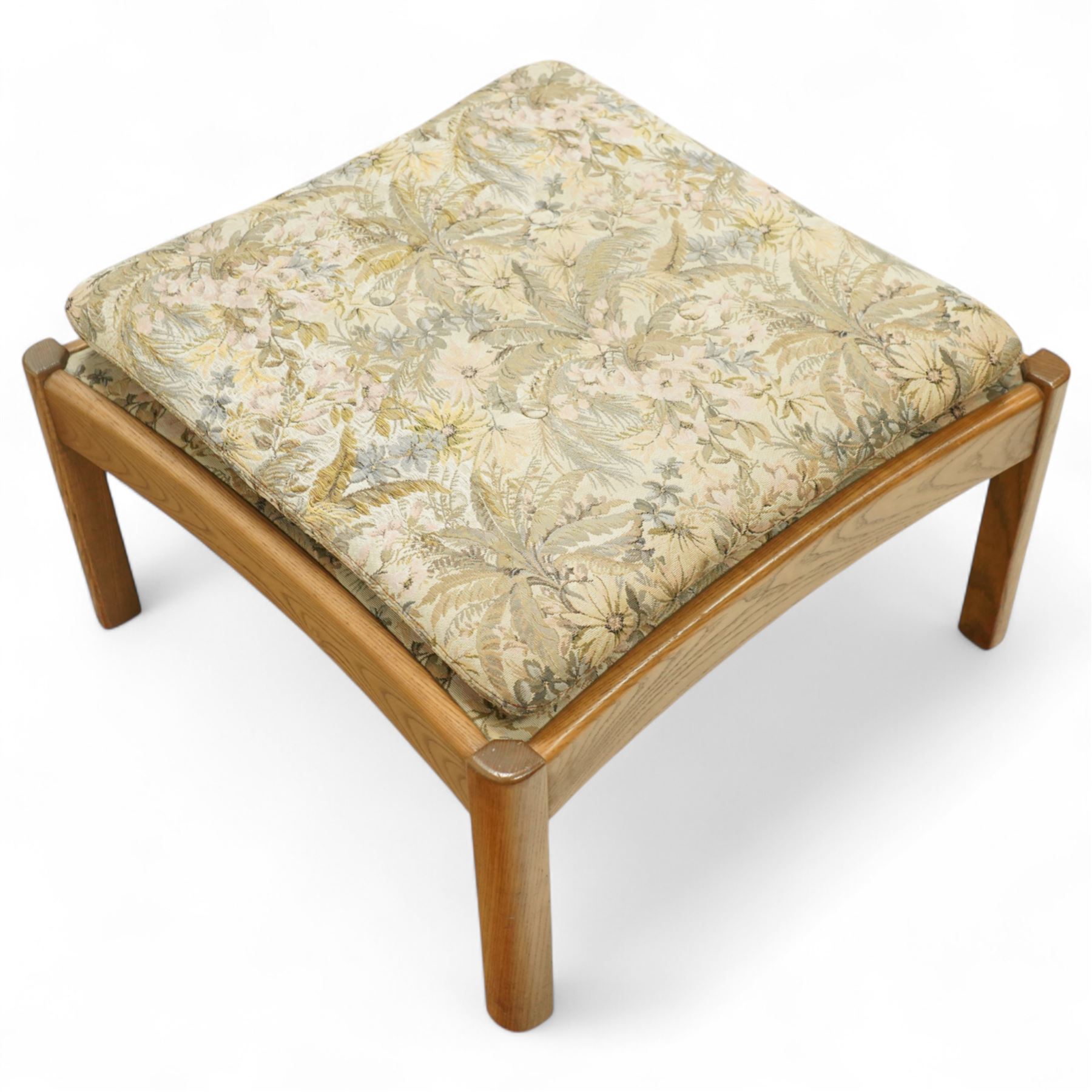Ercol - golden elm 'Saville' armchair and matching footstool, elm frames with curved back supports and slatted sides, removable cushions upholstered in floral tapestry fabric, footstool (H 39cm, W 59cm)