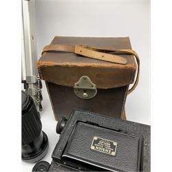 Ensign Focal Plane Roll Film Reflex camera in a brown leather carrying case with purple lining, together with a Canon T70, a leather camera case, and tripod.  