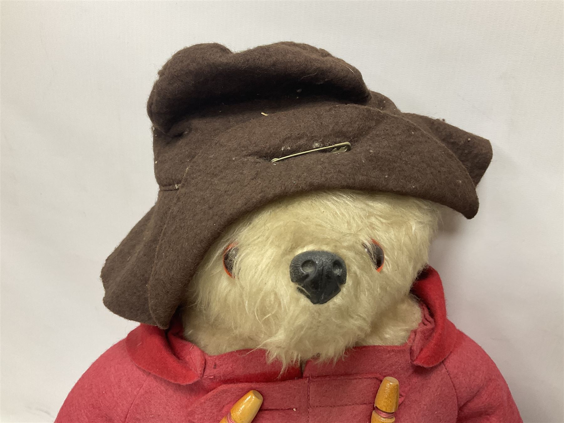 Pair of Paddington Bear teddies with amber eyes, the first example having a brown felt hat, red coat and blue PB boots with original label; the second having a grey felt hat, blue coat and blue Dunlop boots, tallest H51cm 