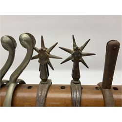 Pair of South American gaucho horse riding spurs with seven-spike rowels, possibly Chilean; and four other pairs of Maxwell type horse riding spurs displayed on an Edwardian purpose-made mahogany rack in the form of a stable saddle rack L37cm