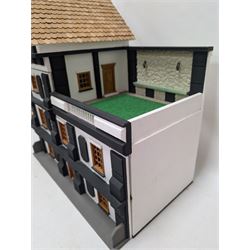 1:24 scale four-storey tudor-style dolls house, with black and white exterior, balcony garden, glazed panelled windows and wooden shingle roof, with decorated interior and wired fireplaces and lighting, H65cm, W58cm, D31cm, 