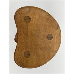 'Mouseman' oak three legged stool with dished kidney shaped seat, tapered octagonal supports, with carved mouse signature, by Robert Thompson of Kilburn 