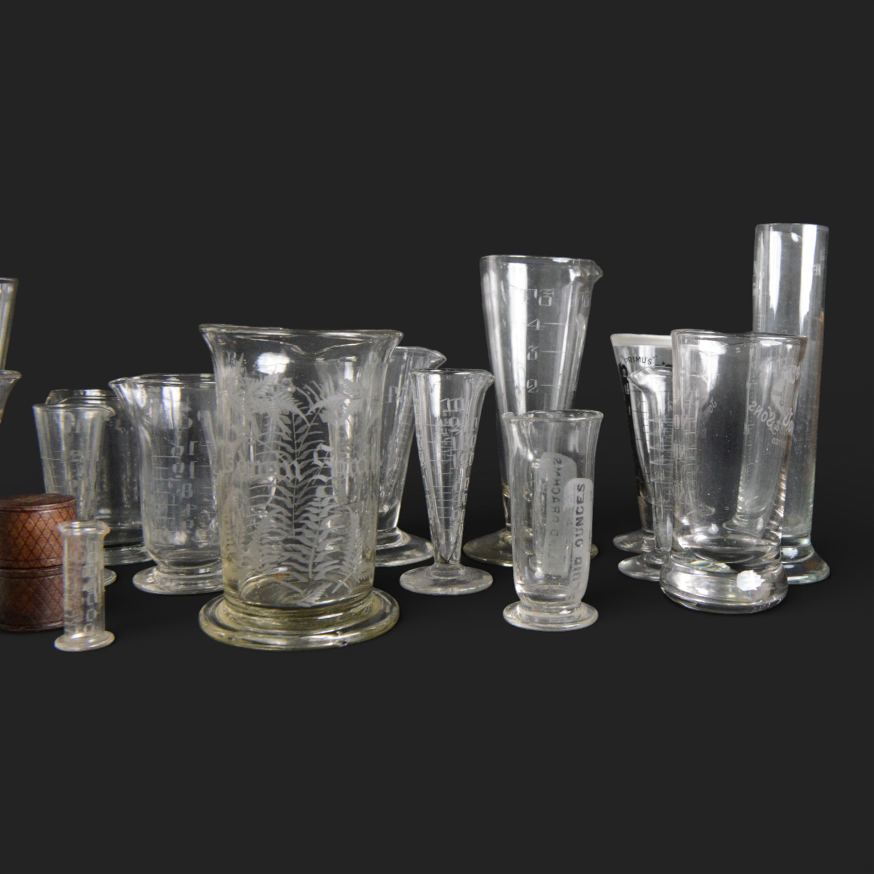Nineteen apothecary chemists glass measures, of various shapes and age 