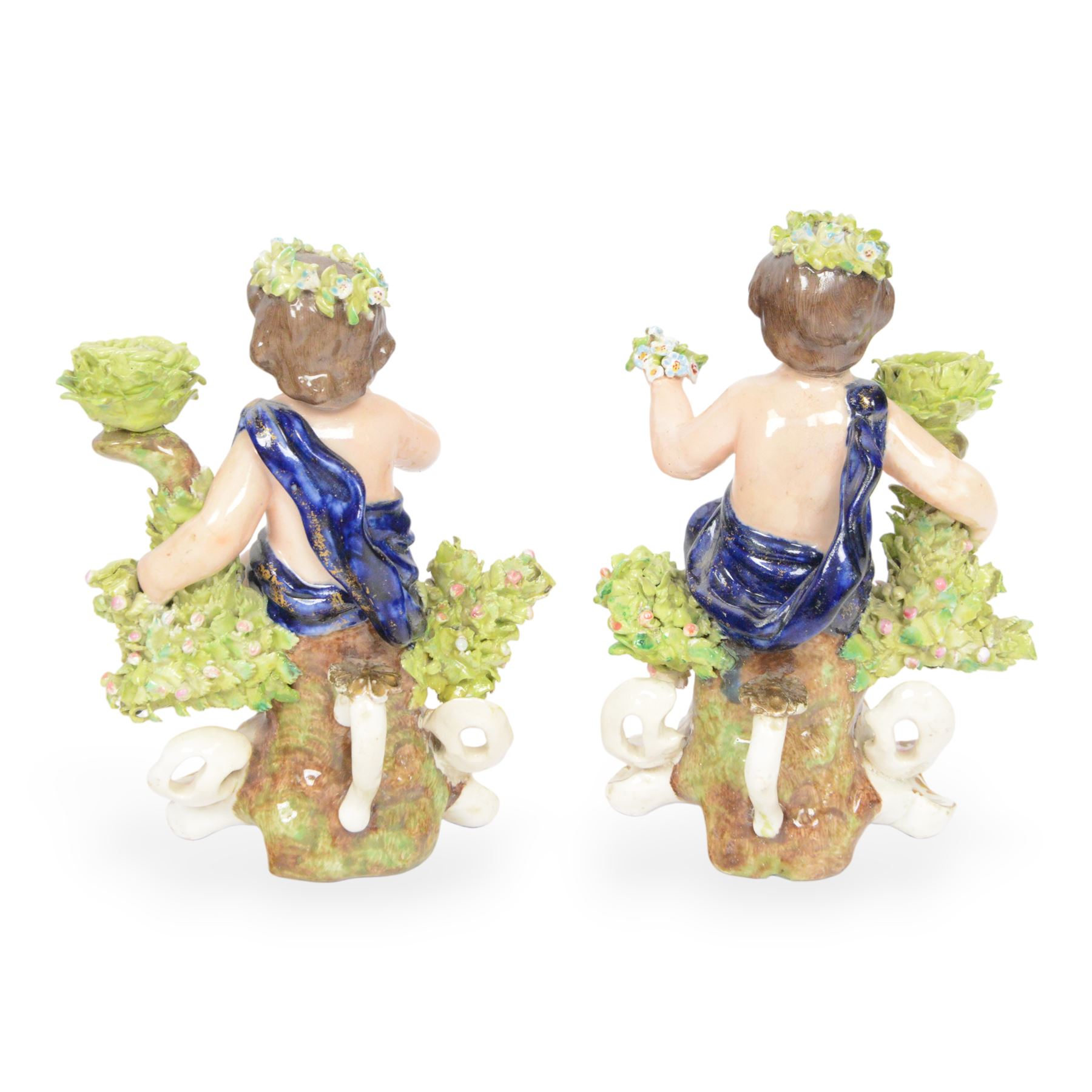 Pair of 19th century Stevenson and Hancock Derby figural chambersticks, each modelled as a seated cherub with arm around foliate encrusted sconce, marked beneath, H18cm