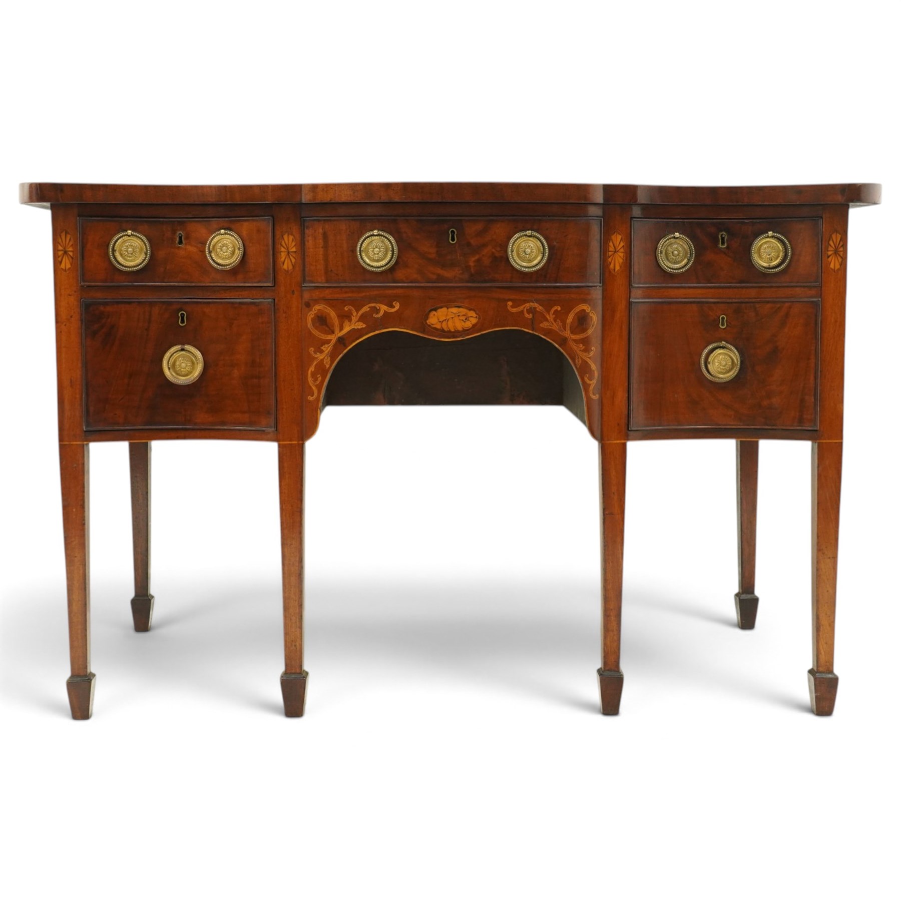 George III inlaid mahogany serpentine sideboard, the shaped top with crossbanding and satinwood stringing, fitted with central bow-front cock-beaded frieze drawer over a shaped apron inlaid with paterae, shell motifs and scrolling foliage, flanked by a deep right-hand drawer and two drawers to the left, raised on square tapering supports with spade feet