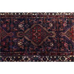 North West Persian Malayer hand-knotted runner, indigo field with vertical lozenge medallions surrounded by angular floral sprays, rosettes, and stylized palmettes, field enclosed by serrated ivory spandrels incorporating polychrome floral decoration, framed by ivory ground main border of stylized flowers and hooked devices, flanked by reciprocal guard stripes, cotton fringe ends 