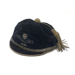 A Victorian rugby cap for Cumberland, the black velvet cap with gold coloured thread and tassel, dated 1888. 