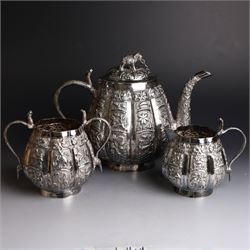 Three piece Indian silver tea service, comprising teapot, twin handled open sucrier and cream jug, each with embossed animal decoration with fish border, serpent handles and elephant finial, teapot H17cm