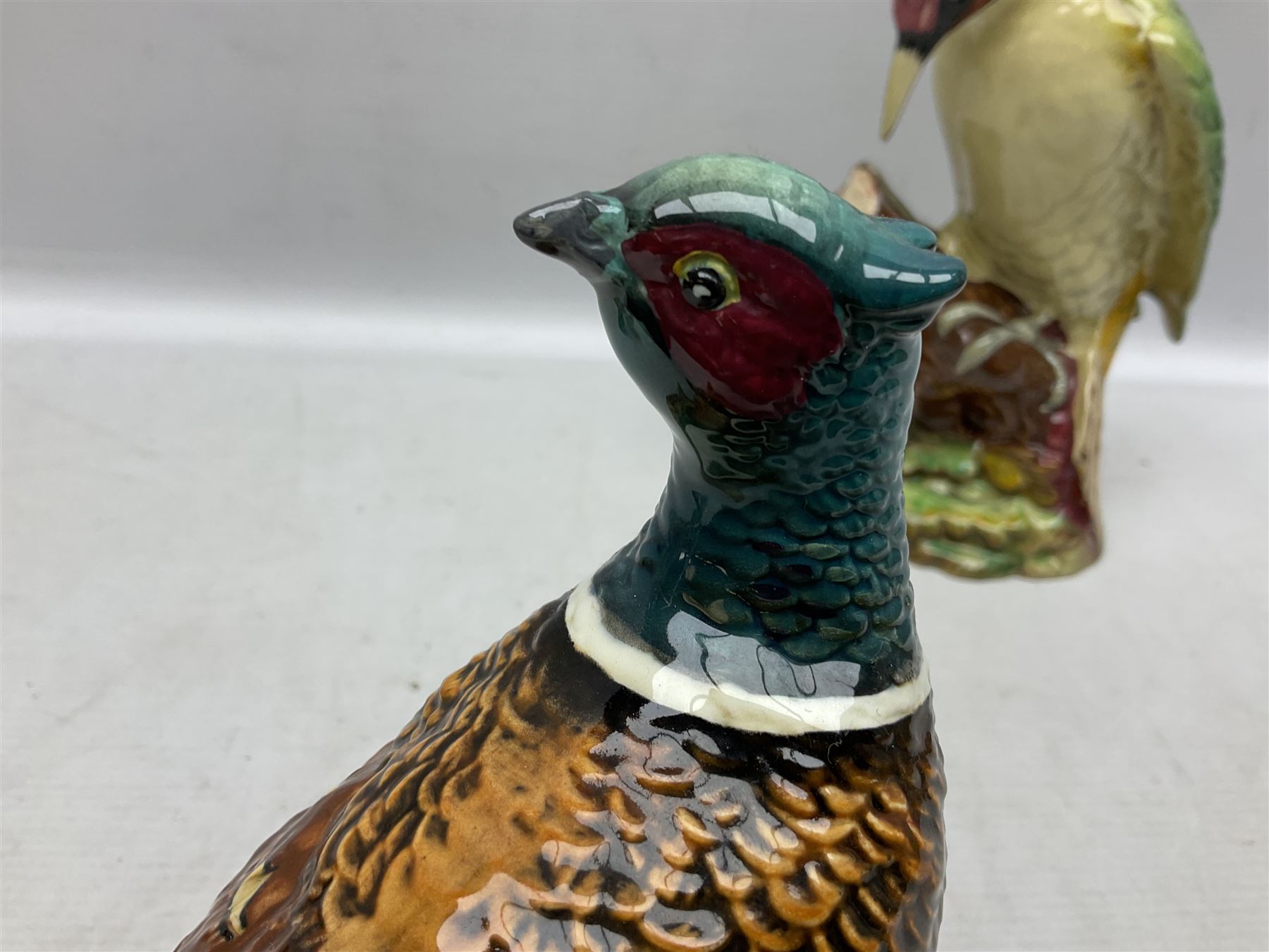Three Beswick figures of birds, comprising pheasant no 1225, magpie no 2305 and woodpecker 1218, all with impressed marks beneath, tallest H22cm