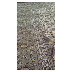 Kashan Persian rug, hand knotted, ivory ground rug, the rosette medallion decorated with projecting palmettes, on a field of swirling leafy branches and decorated with further palmettes, the scrolling border with repeating stylised plant motifs, within floral pattern guard stripes