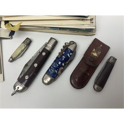 Seven pen knives, two lighters, including one Ronson example and a collection of postcards