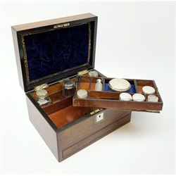 A Victorian rosewood vanity box, with mother of pearl escutcheon and personally engraved plaque to the hinged cover, opening to reveal a velvet and gilt tooled liner and compartmented interior containing a selection  of cut glass bottles and jars, a number with silver plated covers, H17cm L30cm D23cm.  
