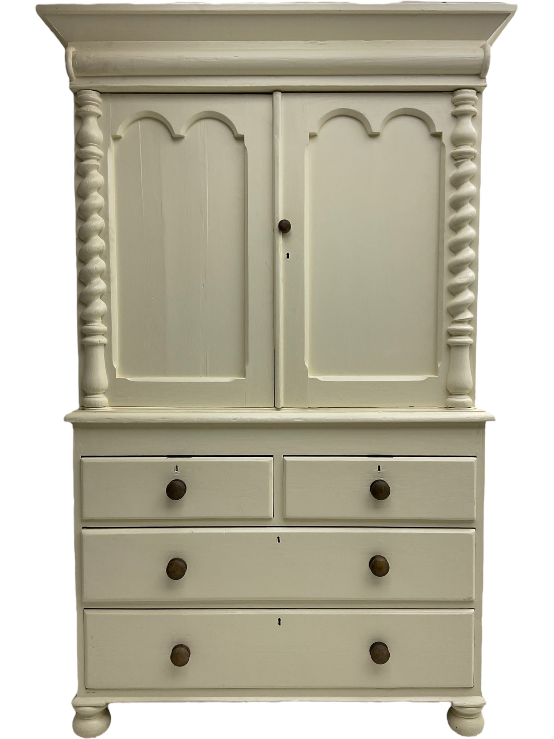 Victorian cream painted pine cupboard-on-chest or housekeeper's cupboard, projecting cornice over two double-arch panelled cupboard doors enclosing two shelves, flanked by spiral turned uprights, base fitted with two short over two long drawers, on bun feet