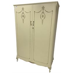 French classic design cream painted double wardrobe, the doors decorated with gilt and cream applied urn motifs with extending bell-flower festoons and ribbon twists, enclosing shelf and hanging rail, shaped apron on acanthus cabriole feet