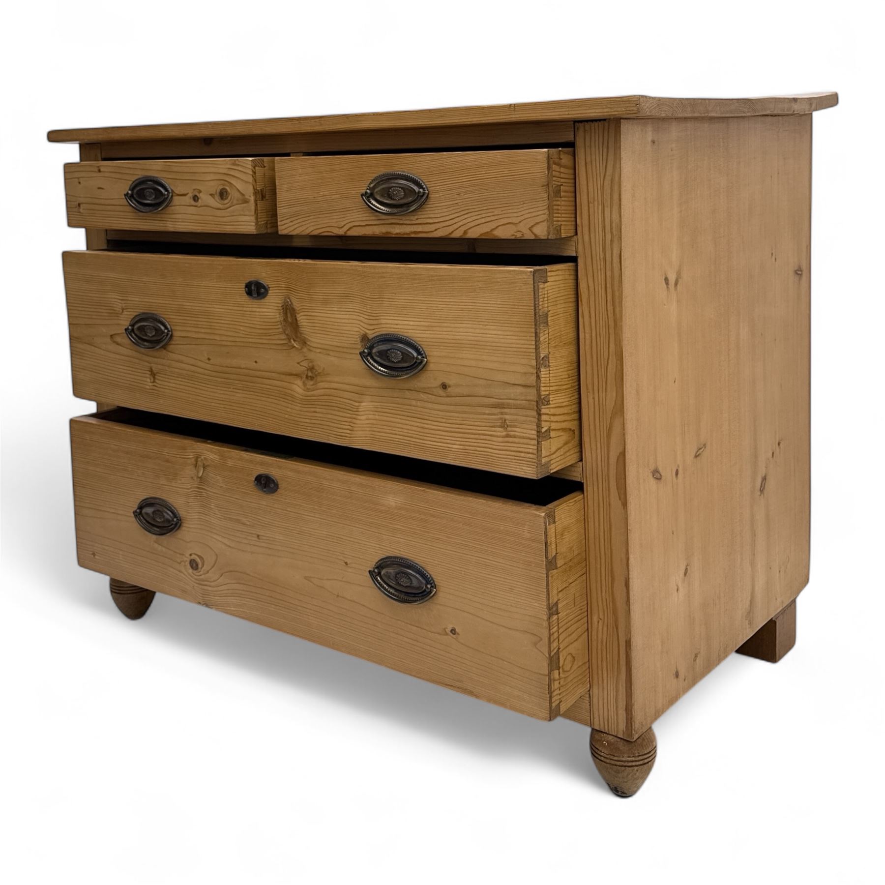 19th century pine chest of drawers, rectangular top over two short and two long drawers with oval pressed brass backplates and drop handles, panelled sides, rounded front edges, on compressed bun feet