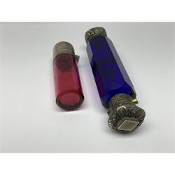 Late Victorian silver mounted ruby glass cylindrical scent bottle, with interior glass stopper, Birmingham 1900, makers mark worn, H8cm, together with a Victorian double ended cut blue glass perfume bottle mounted with white metal screw and flip caps decorated with foliate repousse detailing, H13.5cm