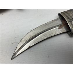 Omani Khanjar dagger, the 12.5cm curved blade with pronounced medial rib to either side, waisted horn style hilt with dome shaped pommel and inlaid pique work; in an intricately filigree decorated white metal scabbard with rings woven into the belt mount L25cm overall