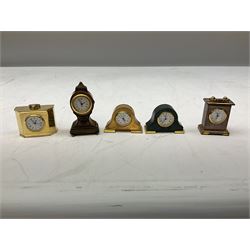 Collection of miniature clocks, predominantly with quartz movements, to include example modelled as an armchair, Edinburgh crystal glass example, clock modelled as a flower, sewing machine etc