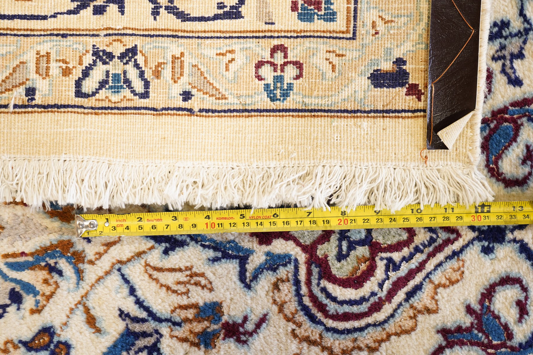 Persian Nain ivory ground rug, the busy oval field profusely decorated with scrolling foliate decoration and palmettes in citrine and indigo tones, the central medallion with matching spandrels, the multiple guard bands with repeating stylised quatrefoil motifs and trailing scrolling foliage and flowerheads