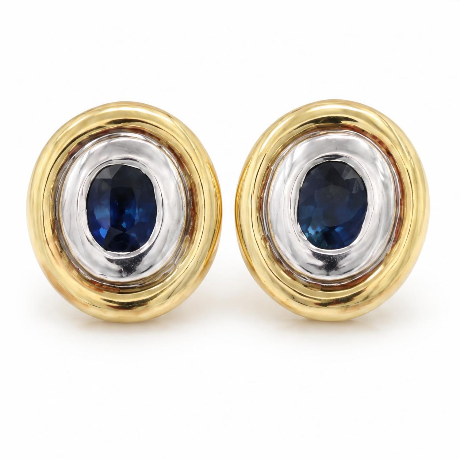 Pair of 14ct gold synthetic sapphire earrings and pendant, each rubover set with a single oval cut sapphire, within a white and yellow gold oval surround